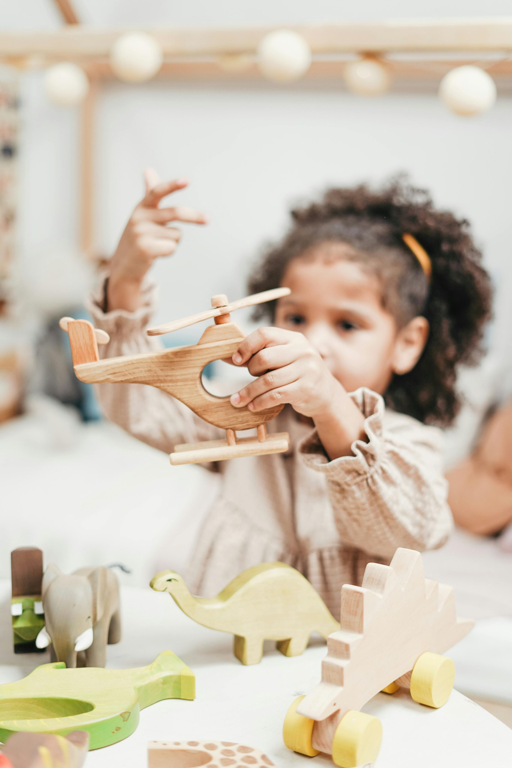Child having fun with wooden toys in a playroom setting.